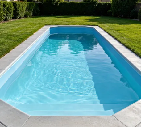 A residential inground pool viewed from the deck, showing the vinyl liner along the walls and floor beneath clear water A residential inground pool viewed from the deck, showing the vinyl liner along the walls and floor beneath clear water